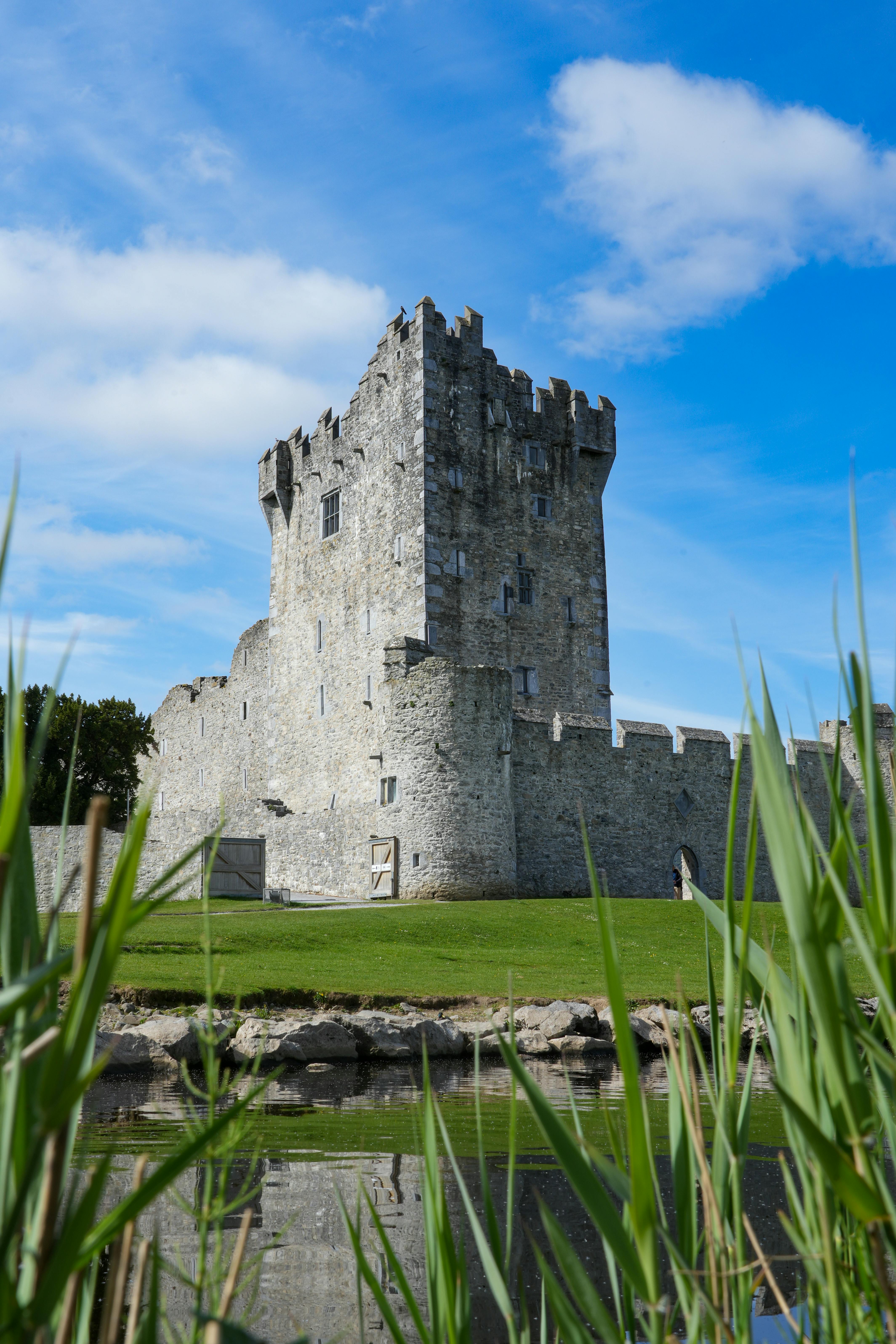 A striking medieval castle tower set against a vibrant blue sky in Ireland, reflecting heritage and history.