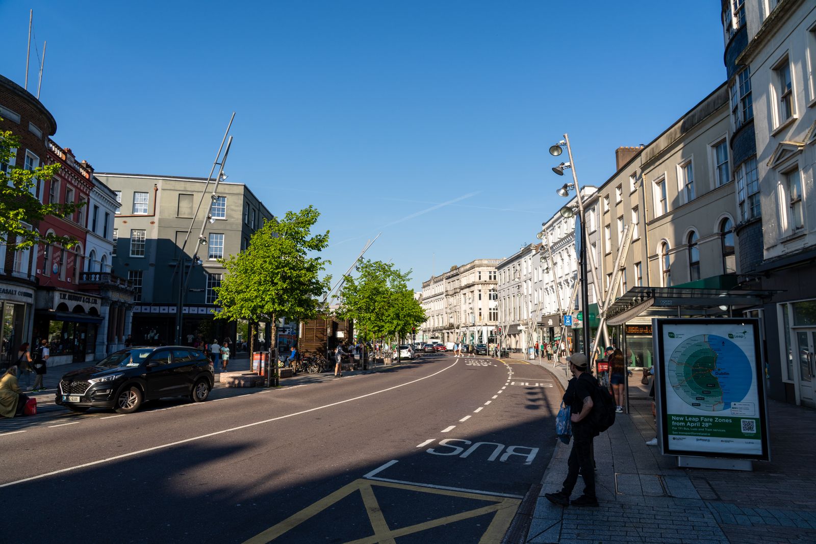 Sunny street view in Cork, Ireland, showcasing architecture and daily urban life