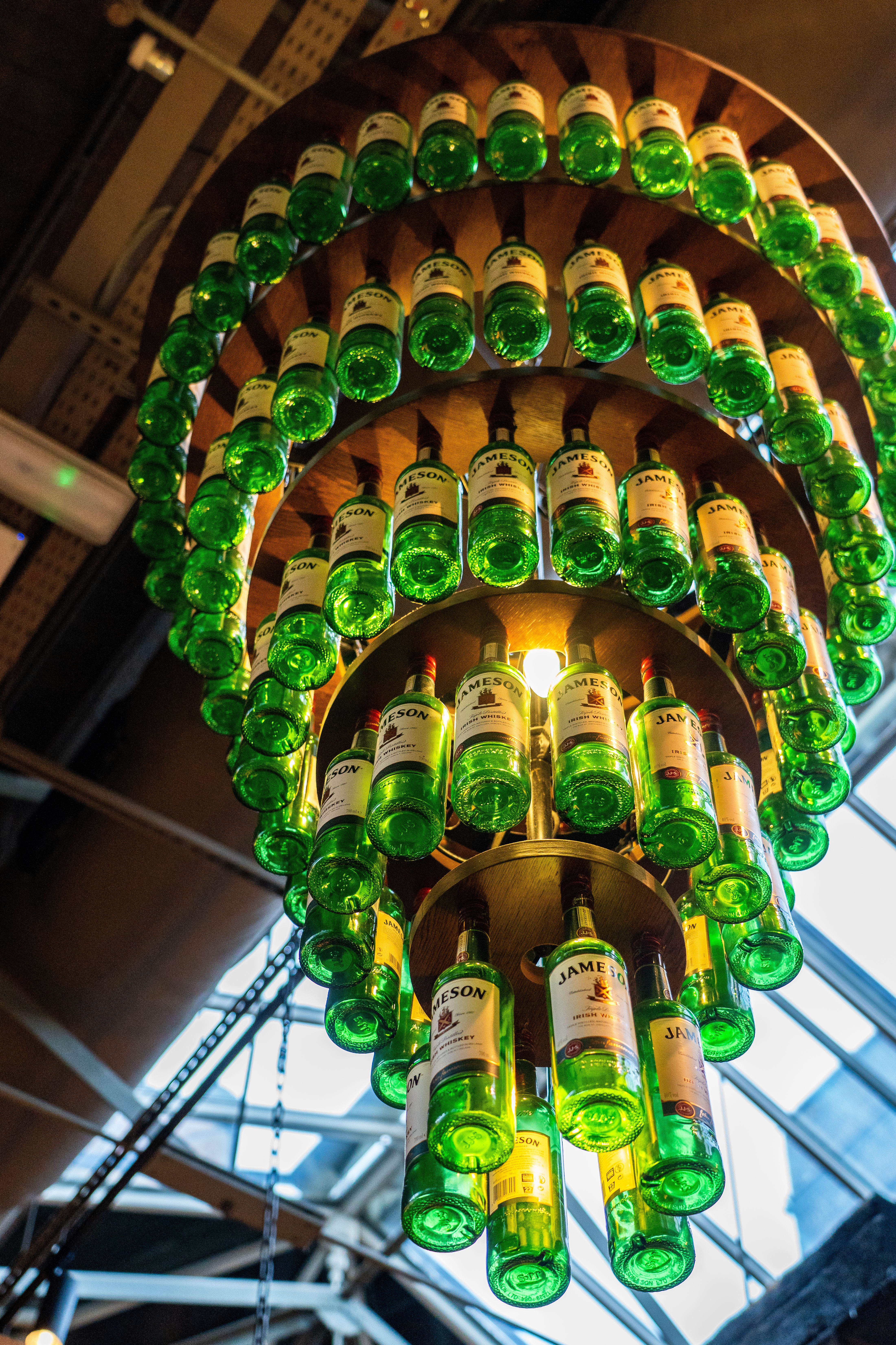 Stunning chandelier made of green Jameson bottles in an Irish setting, showcasing creativity and design.