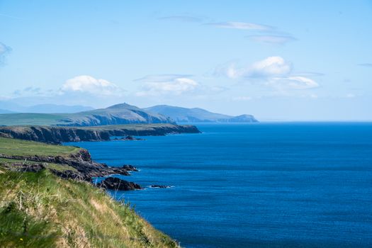 Explore the stunning coastline of Ireland with lush cliffs and vibrant blue waters.