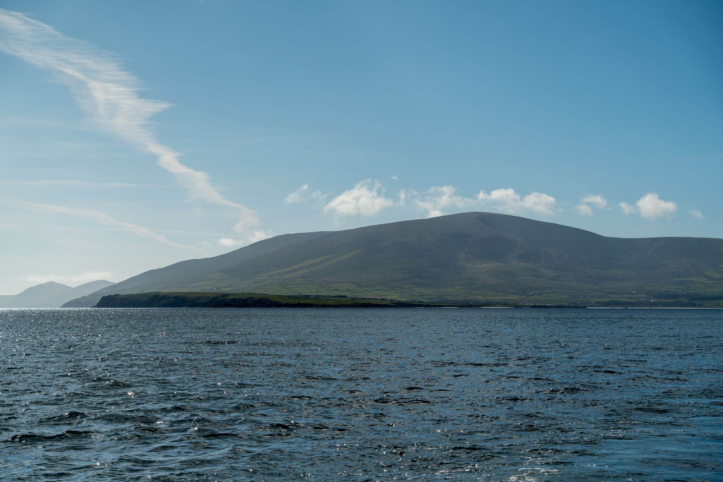 View of the Dingle Peninsula in Ireland with clear skies and calm waters