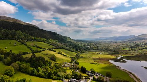 Free A breathtaking aerial view of Ireland's lush green hills and valleys under a cloudy blue sky. Stock Photo