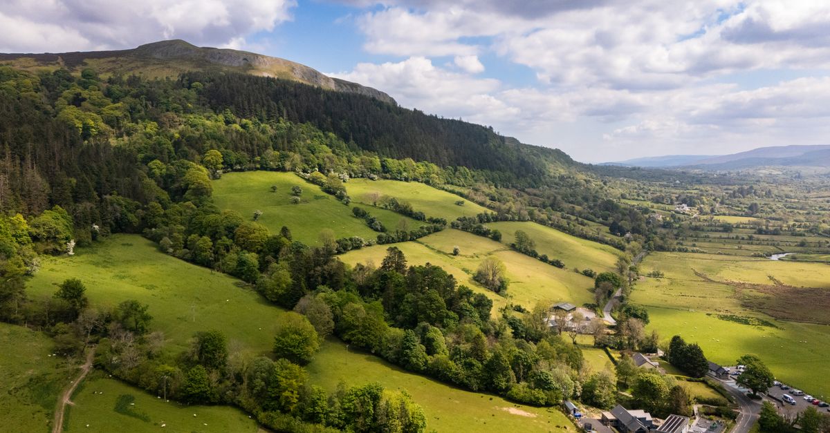Aerial view of the scenic green hills and valleys in Ireland on a sunny day.