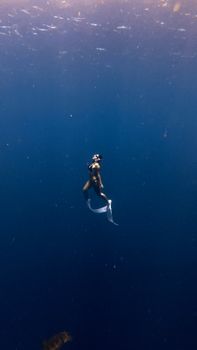 A solitary freediver explores the deep blue sea, showcasing underwater serenity and adventure.