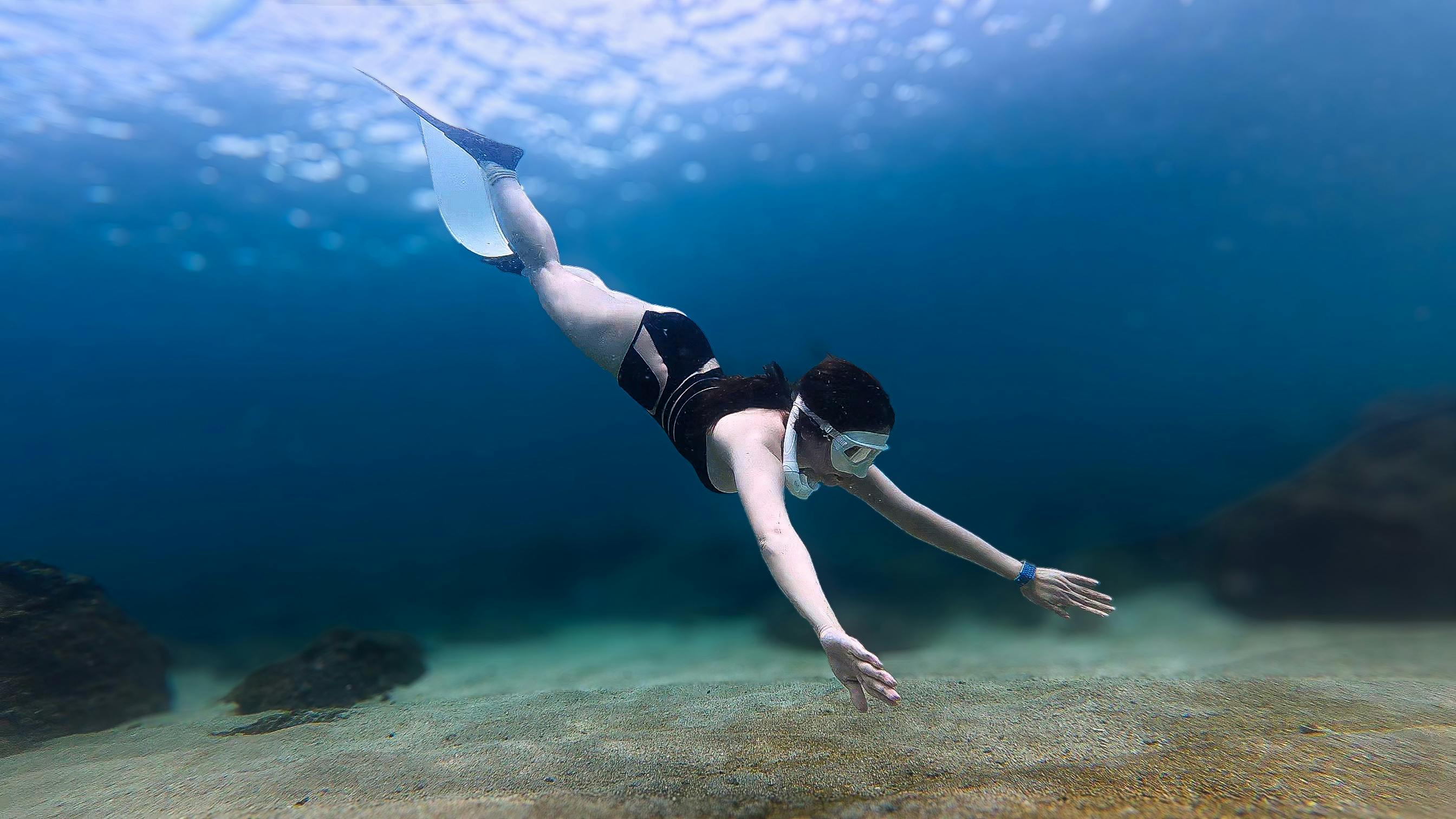 A serene image of a woman freediving in clear blue ocean waters capturing the essence of underwater exploration.