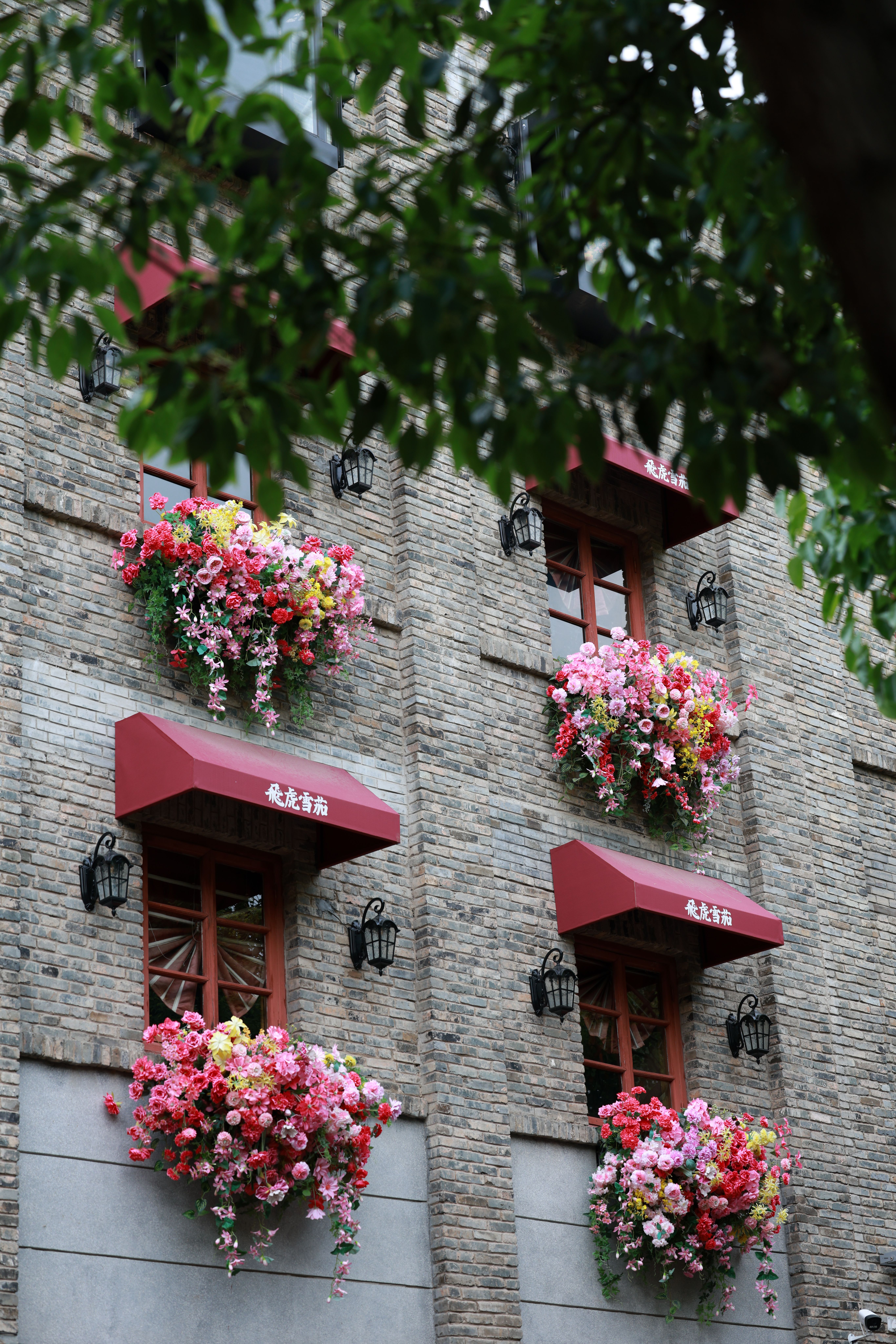 Picturesque brick building with vibrant floral displays on windows, perfect urban charm.