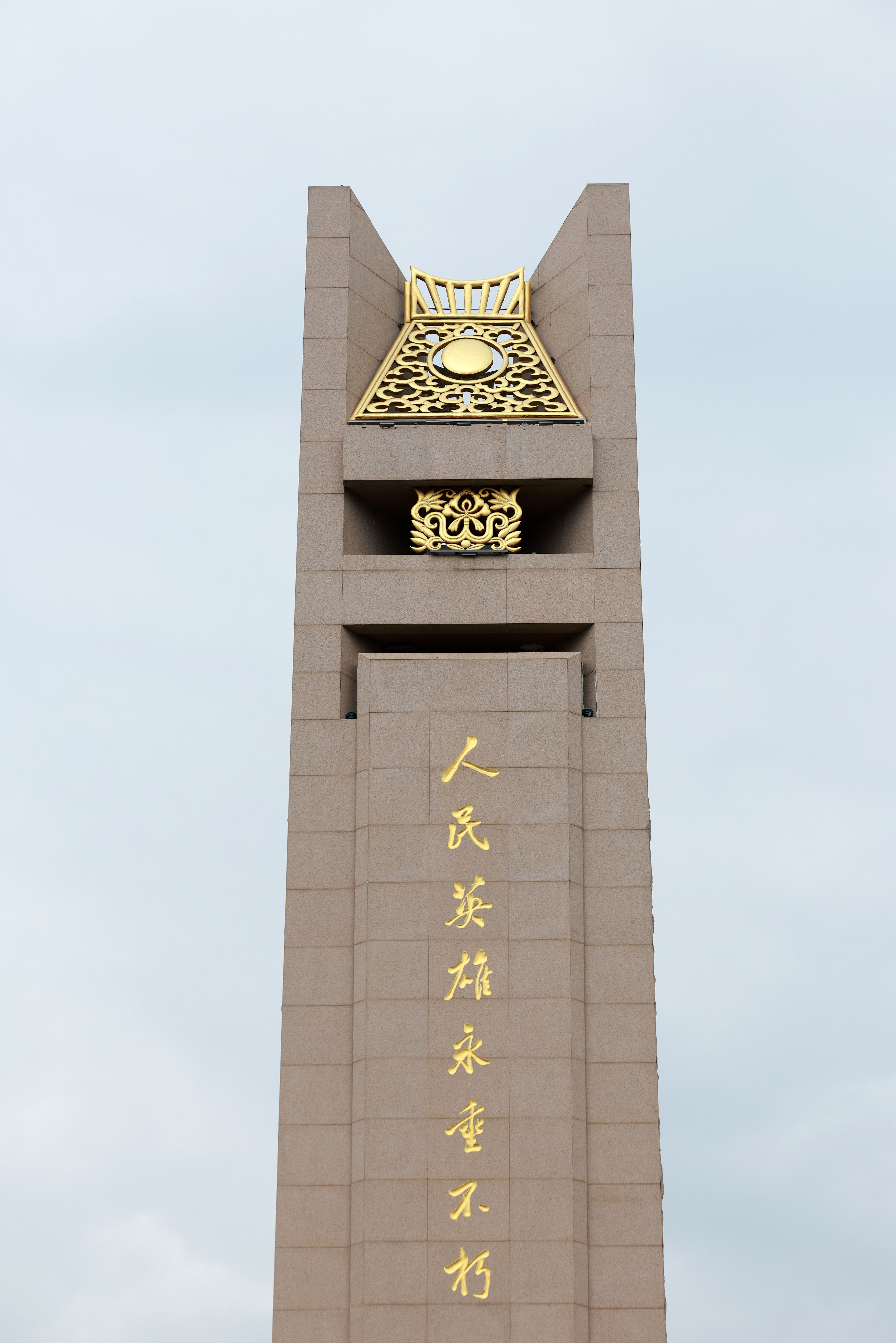 Tall Monument with Gold Inscriptions Against Blue Sky · Free Stock Photo
