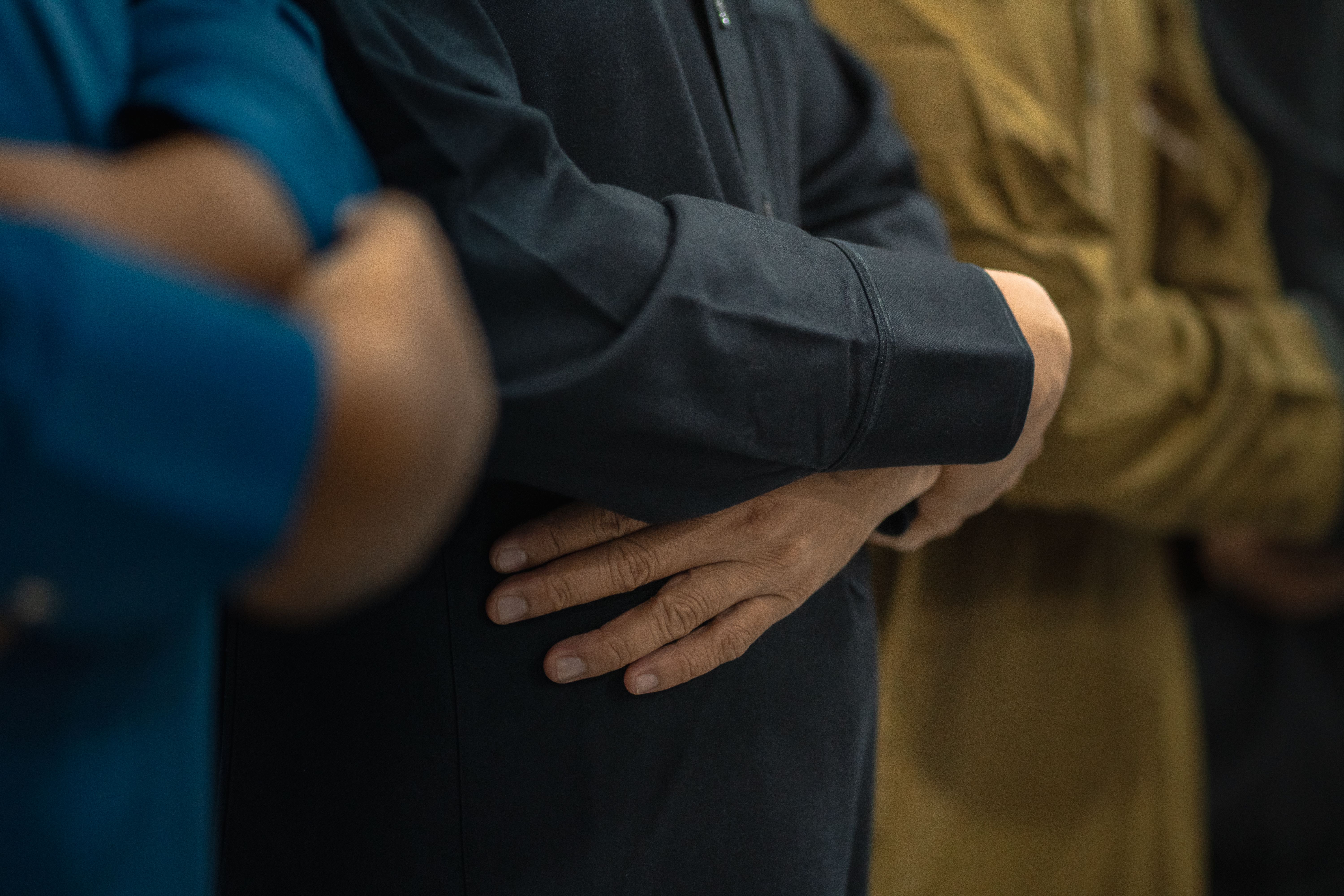 Adult men performing an Islamic prayer indoors in Sulawesi Selatan, Indonesia.