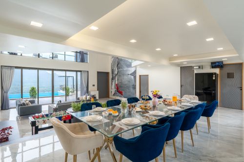 Free Spacious modern dining room with pool and mountain view, featuring elegant decor and seating. Stock Photo
