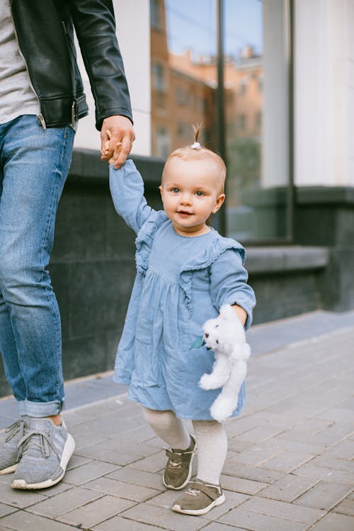 Free A Girl is Walking While Holding Her Fathers Hand Stock Photo