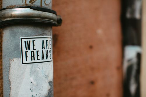 Free Close-up of a rusty metal pipe with a 'We Are Freaks' sticker, showcasing urban decay. Stock Photo