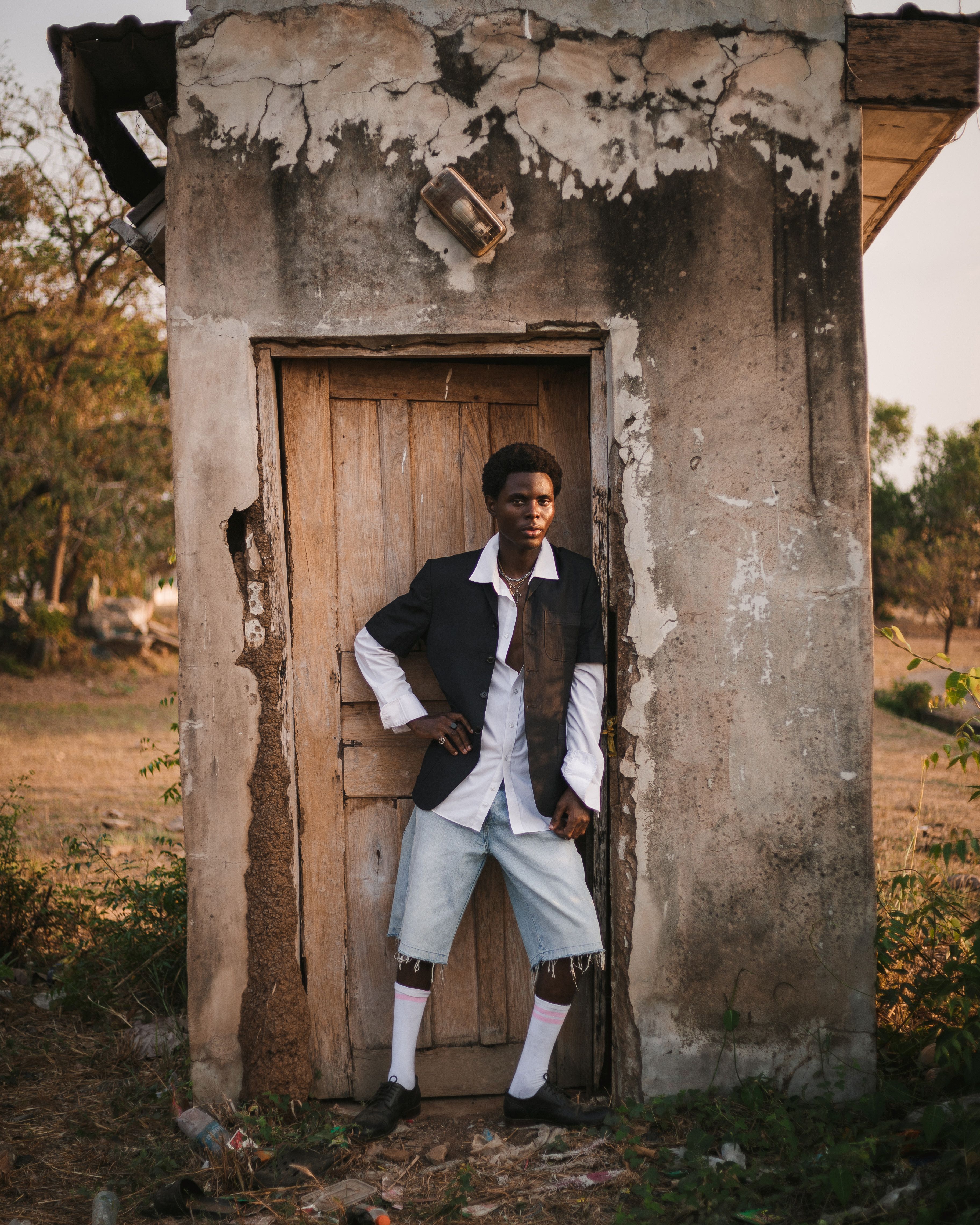 Stylish Man Posing by Rustic Structure Outdoors · Free Stock Photo
