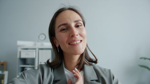 Free Portrait of a smiling woman in an office setting, promoting positivity. Stock Photo