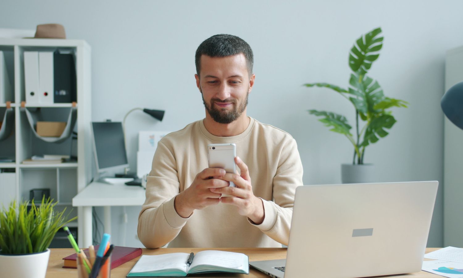 Empleado de una startup consultando el móvil en la oficina fuera de su horario laboral