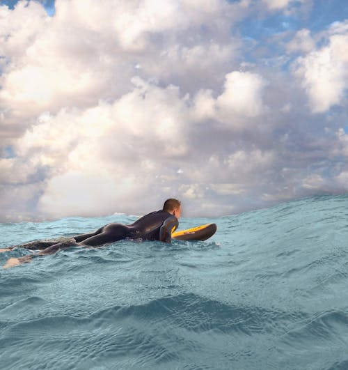 Người đàn ông Lướt Trên Sóng Biển Dưới đám Mây Trắng