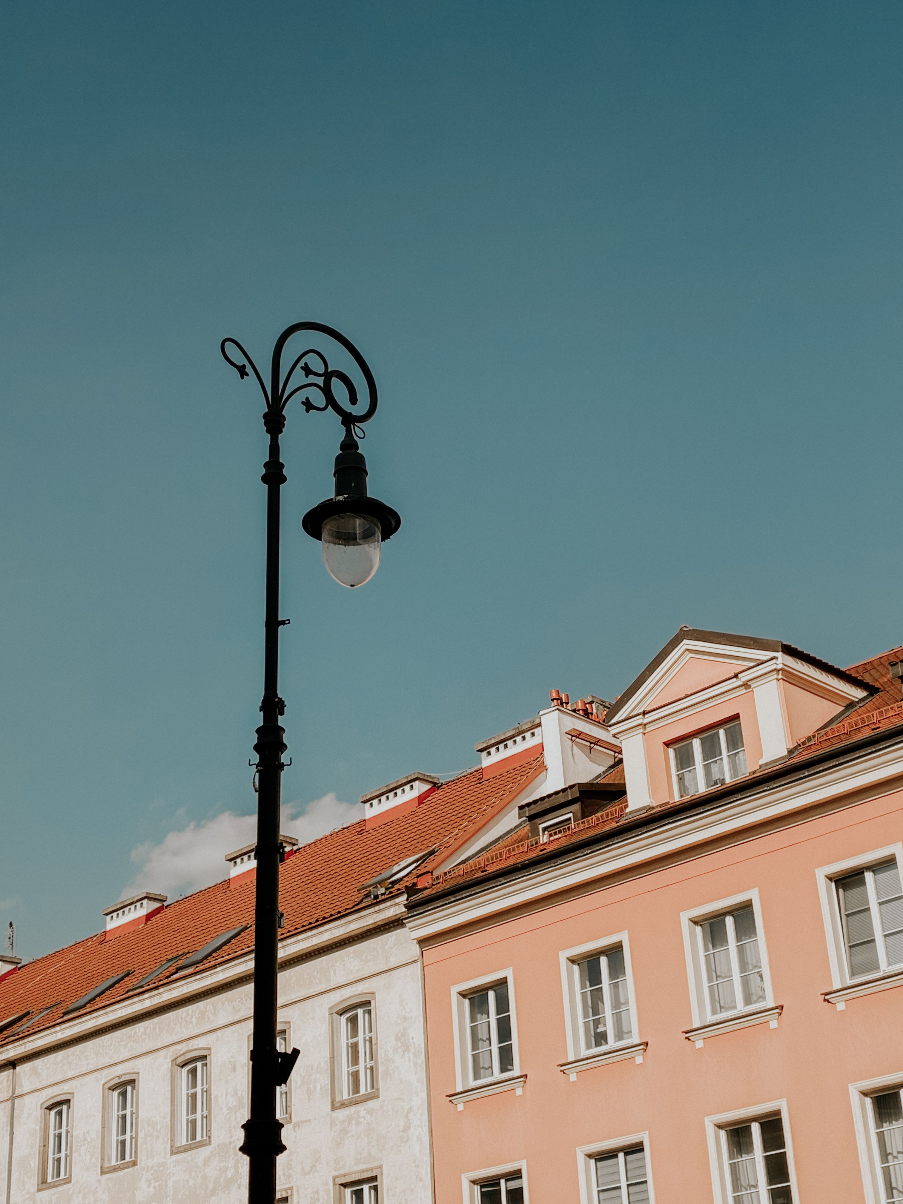 Elegant buildings with a streetlamp in Warsaw, Poland. Classic European architecture under a clear blue sky.