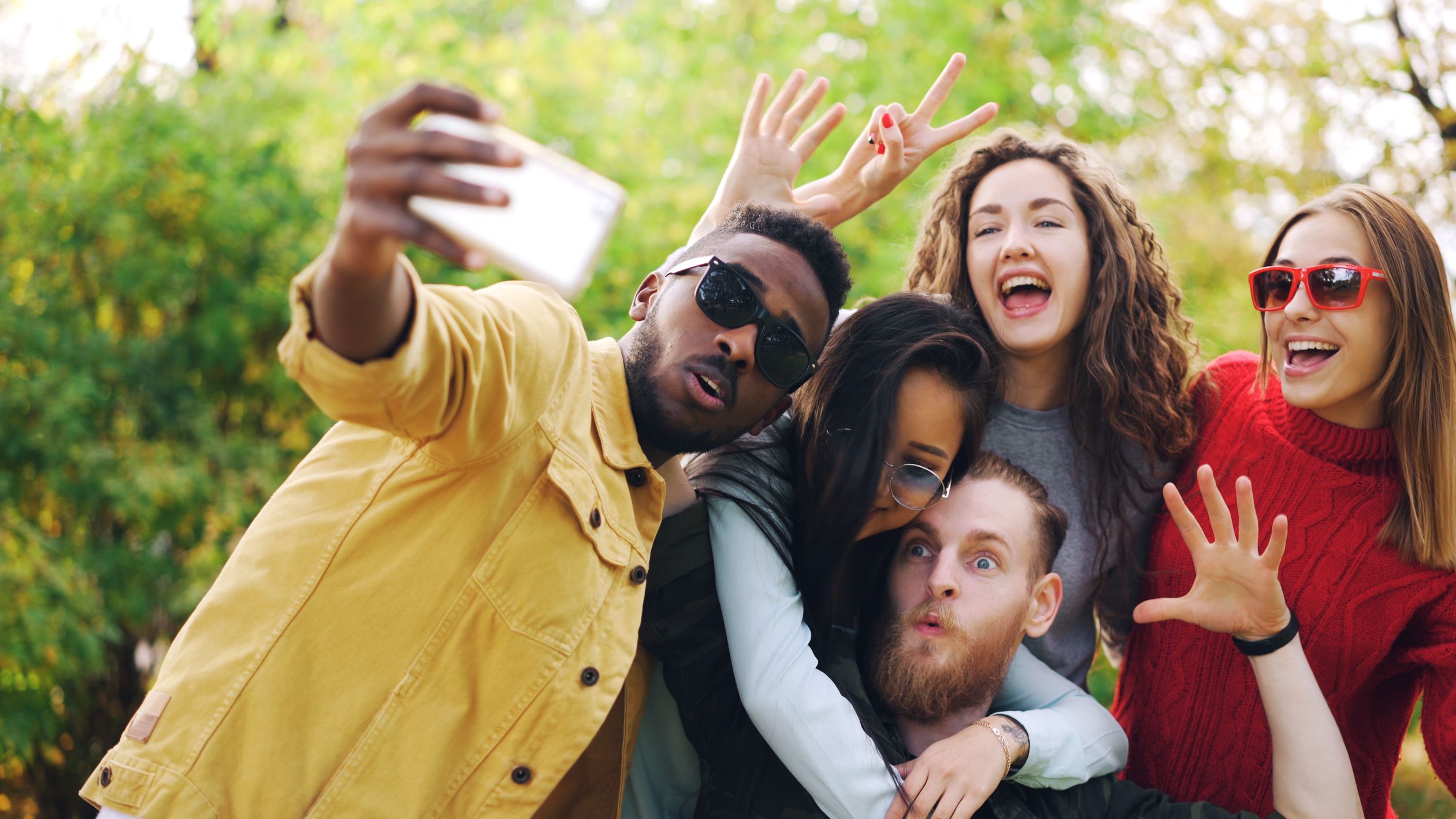 Happy Friends Taking a Group Selfie Outdoors · Free Stock Photo