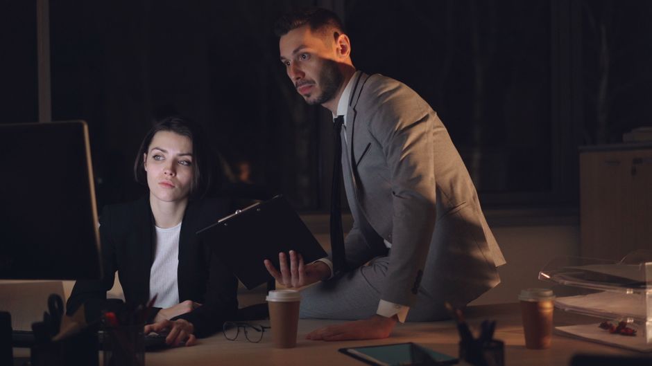 Profesionales corporativos dedicados a una sesión de trabajo en la oficina durante la noche.