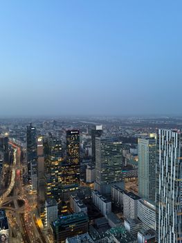 Stunning aerial view of Warsaw's skyline during twilight showcasing modern skyscrapers and city lights.