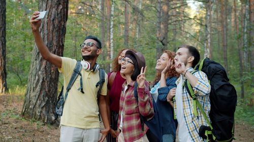 Free Happy group of friends capturing a selfie during a forest hike. Stock Photo