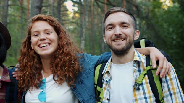 Two friends smiling during a forest hike, enjoying nature and friendship.