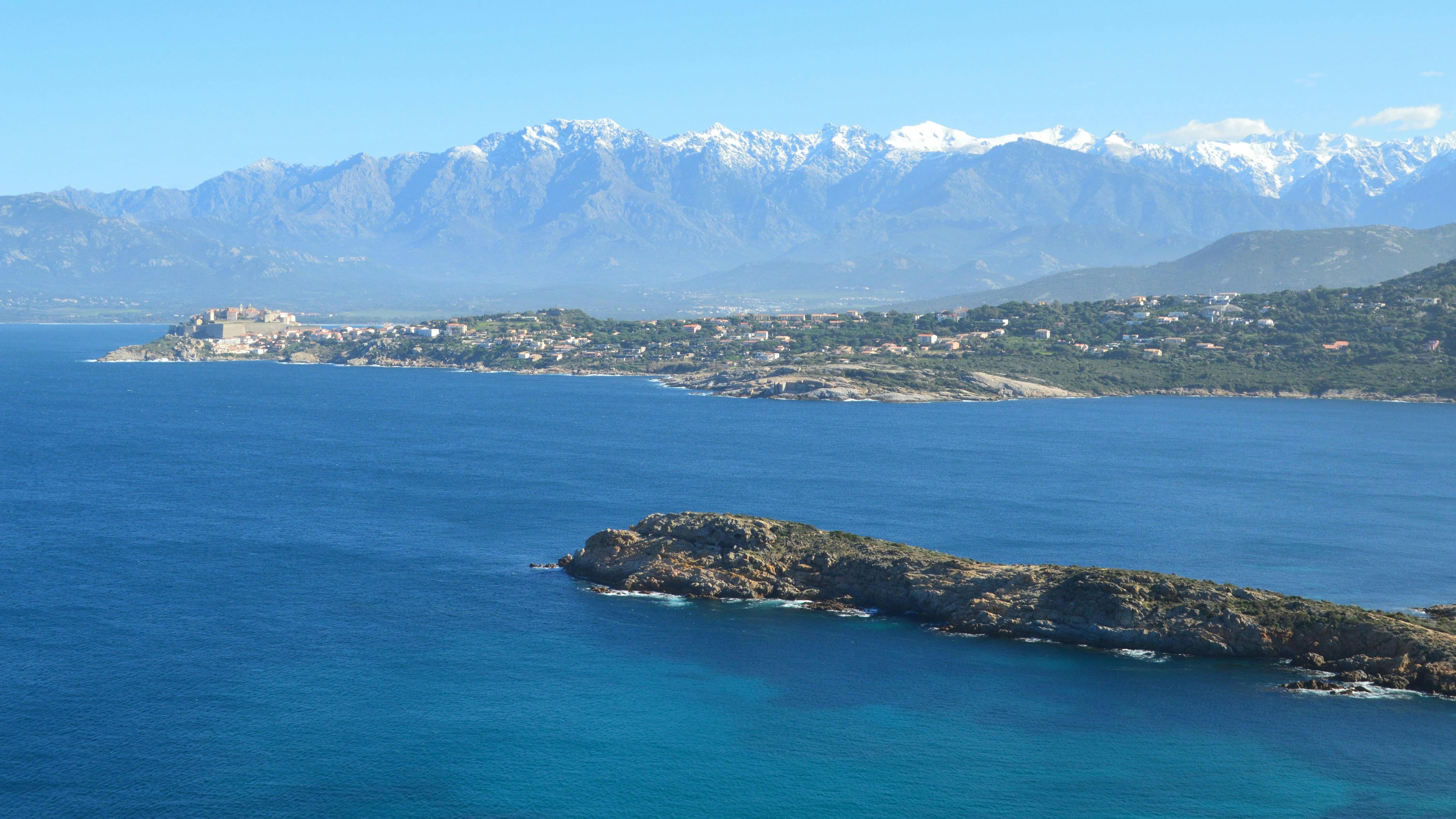 Explore the breathtaking landscape of Calvi with blue sea and majestic mountains in Corsica, France.