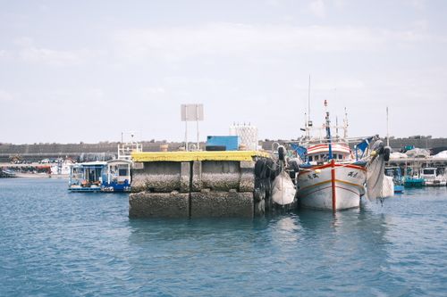 Free Vibrant fishing boats docked at a harbor on a sunny day, showcasing a nautical scene. Stock Photo