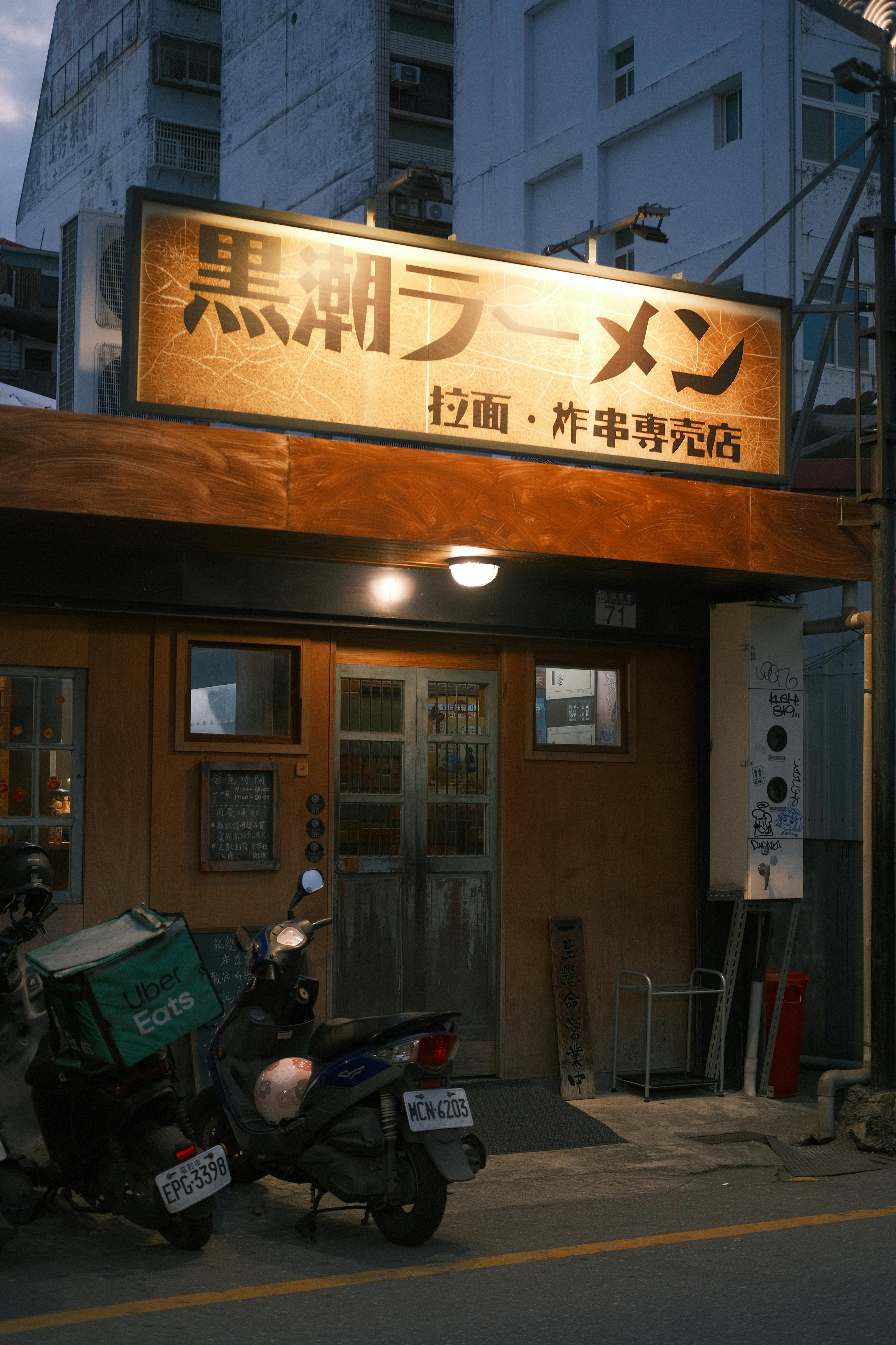 Outdoor view of a ramen restaurant with signage, captured at dusk.