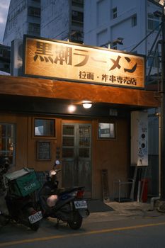 Outdoor view of a ramen restaurant with signage, captured at dusk.