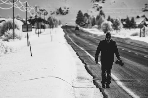 Hombre De Chaqueta Negra Caminando Por La Carretera