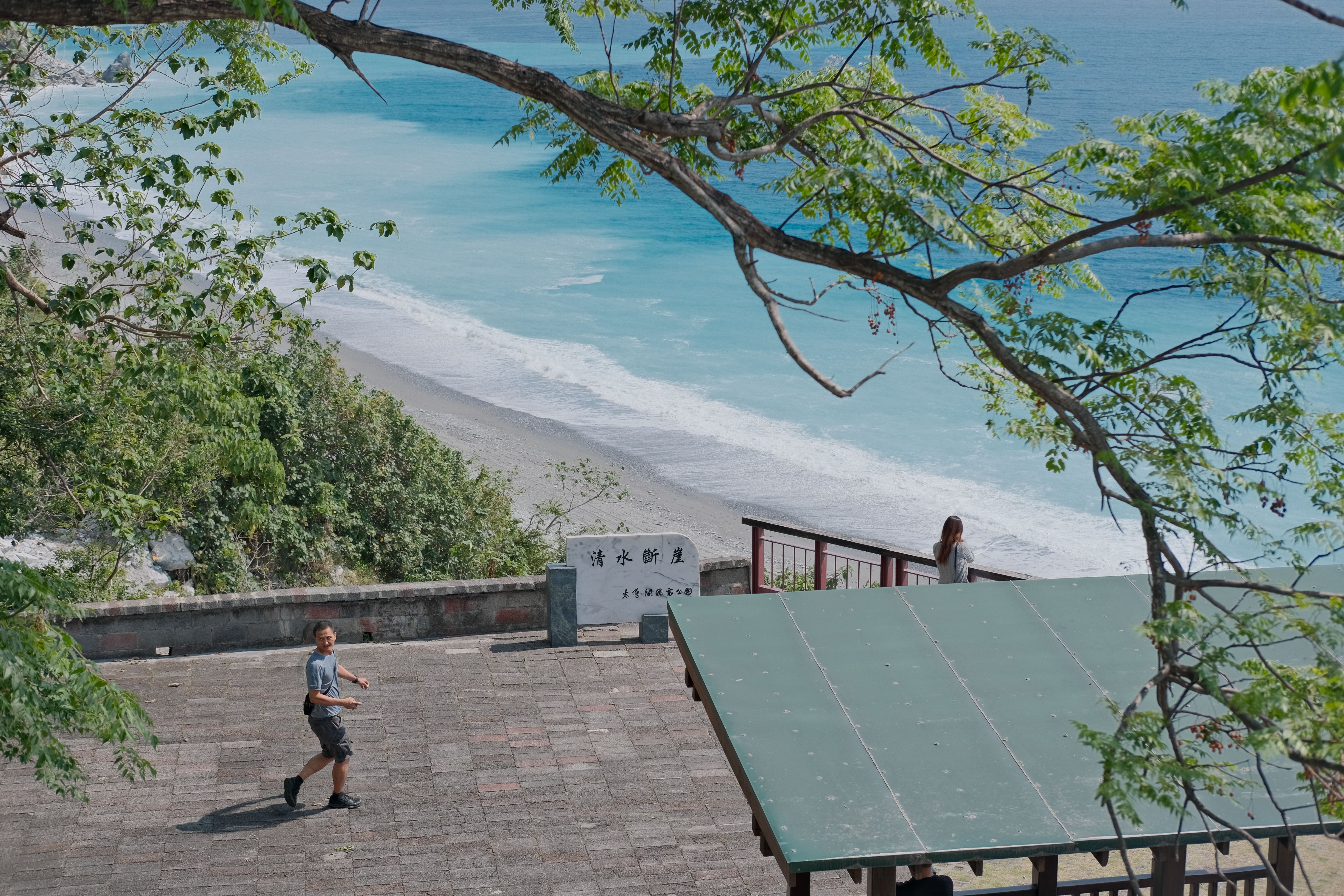 A scenic coastal view from Qing Shui Cliff with people enjoying the seaside atmosphere.