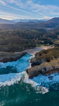 A stunning aerial view of the Cantabrian coastline with cliffs and waves crashing against the rocks.