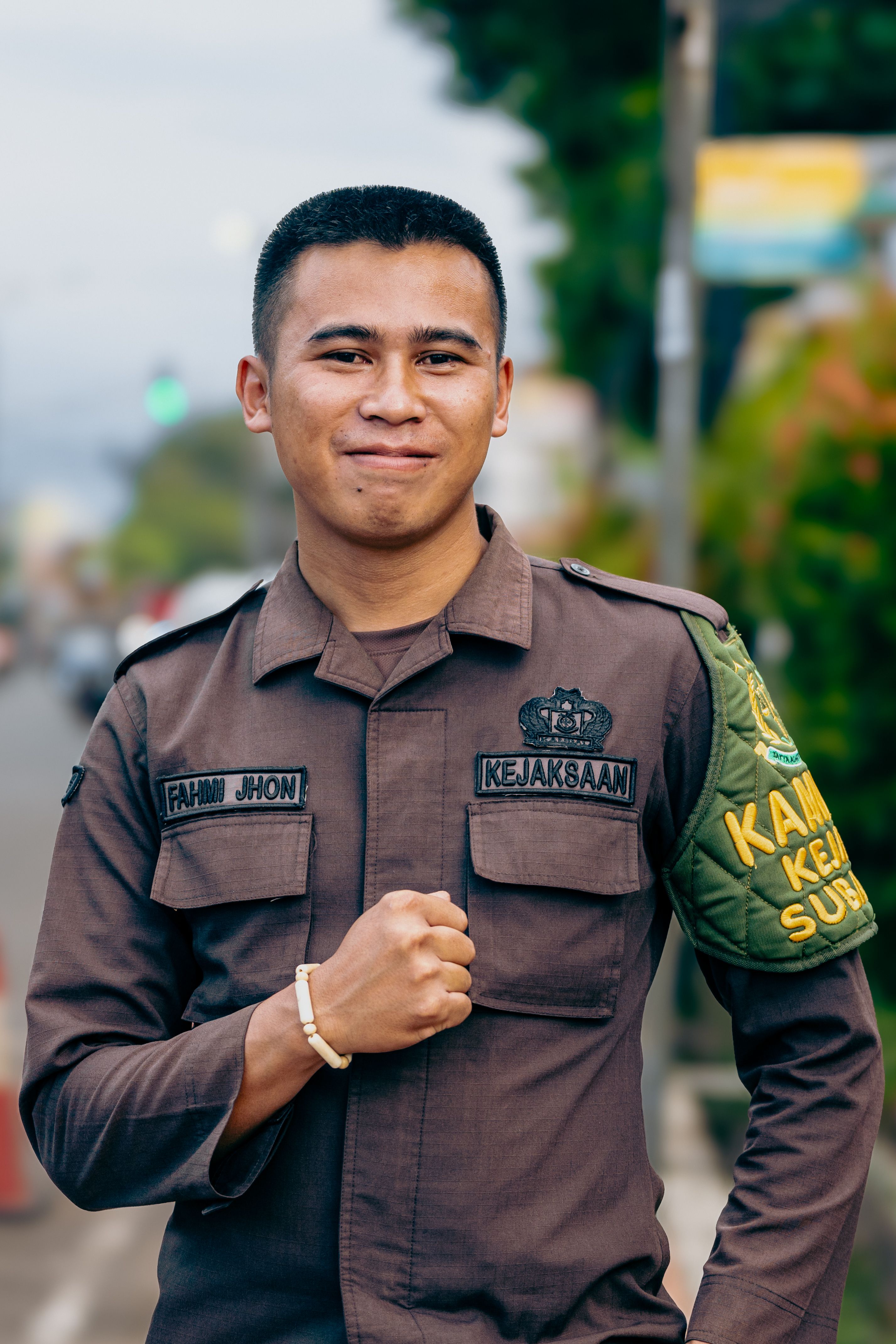 Confident security personnel in uniform smiling on a street in Subang, Indonesia.