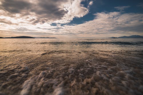 海浪在日落期间在海岸上崩溃