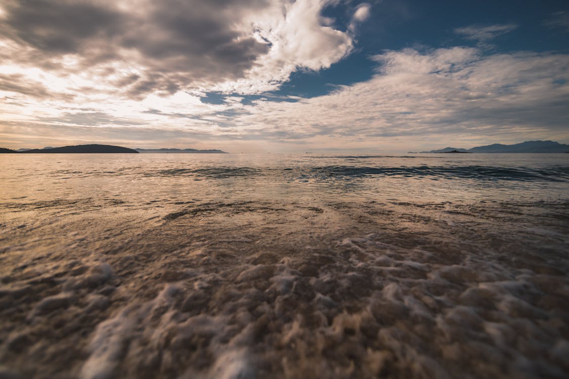 海浪在日落期间在海岸上崩溃