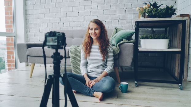 Casual shot of a woman recording a vlog in a cozy home setting.