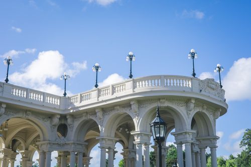 Free Neoclassical pavilion with ornate arches and lampposts under a bright blue sky. Stock Photo