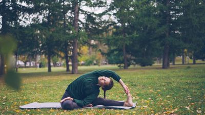 Seated Side Fold — outdoor yoga pose in an autumn park. Photo by Vitaly Gariev on Pexels
