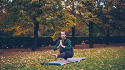 Deep Squat Settle — outdoor yoga pose in an autumn park. Photo by Vitaly Gariev on Pexels