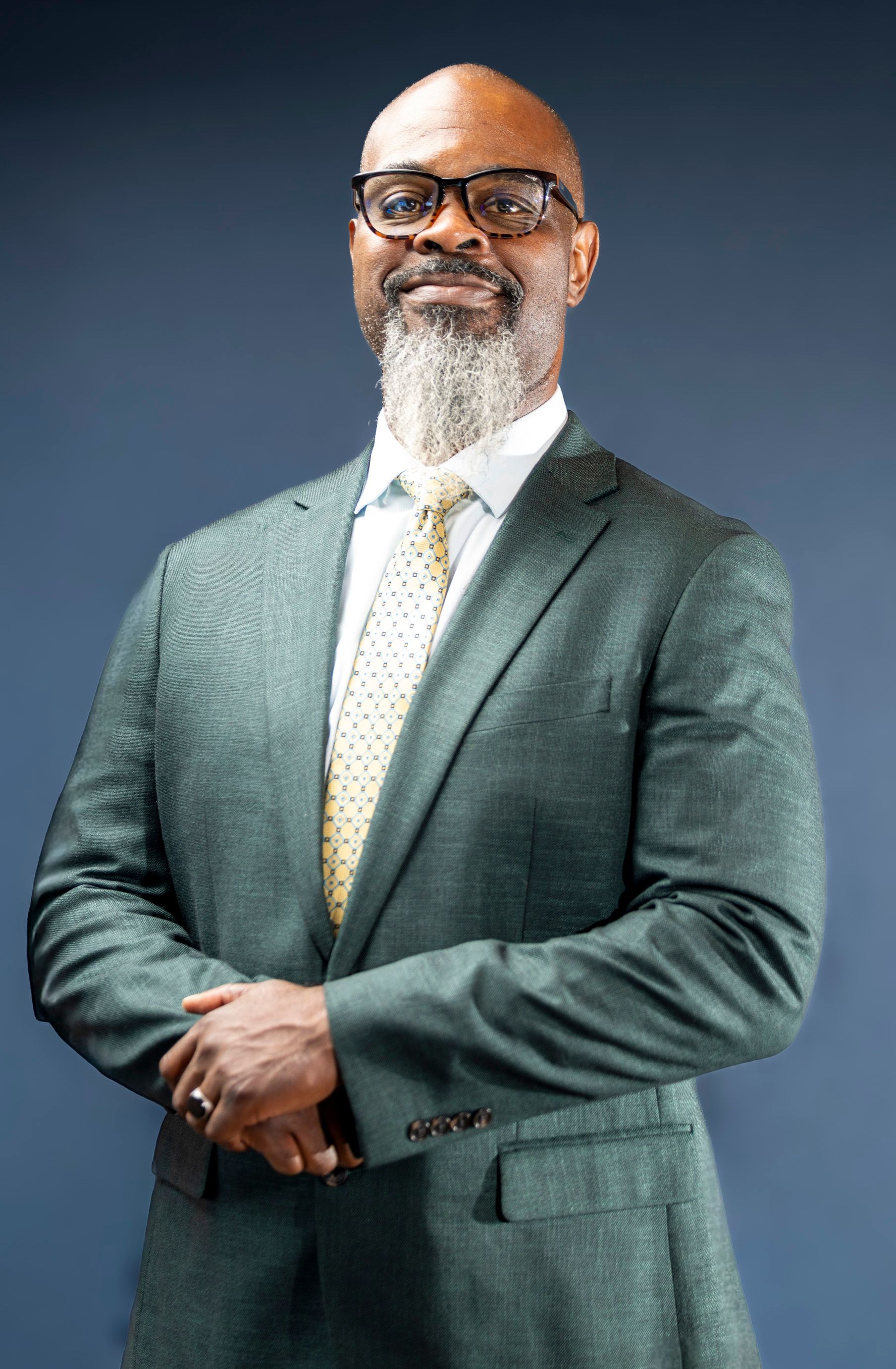 Portrait of a confident businessman in a smart suit with a professional demeanor against a solid background.