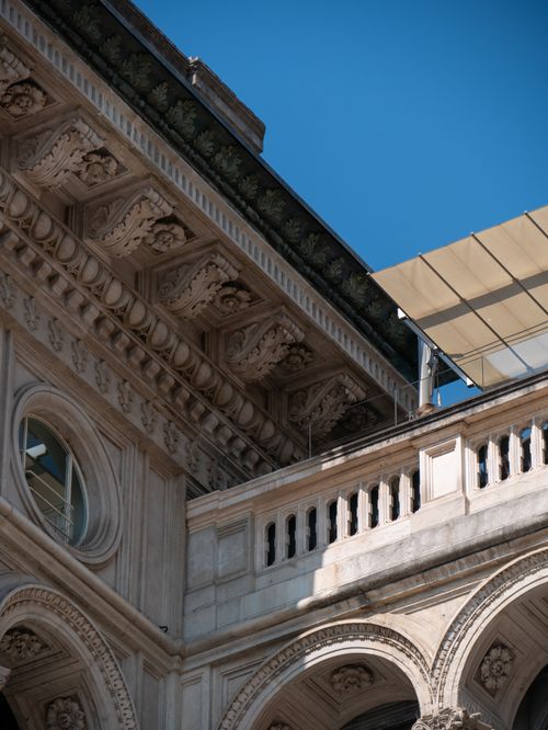 Free Close-up of an ornate historic building facade with detailed carvings under a clear blue sky. Stock Photo