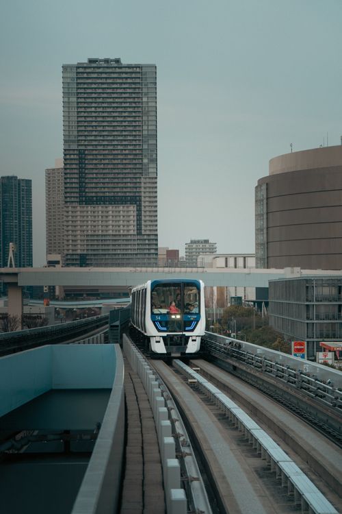 Free A vibrant Tokyo monorail navigating the modern cityscape surrounded by skyscrapers. Stock Photo