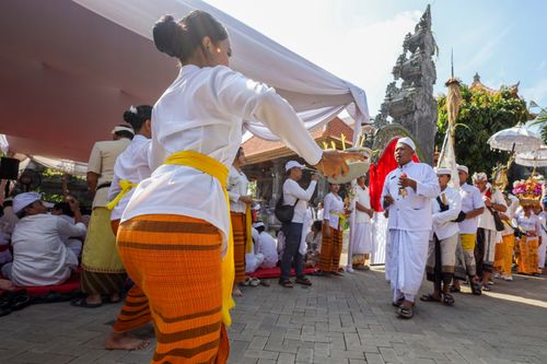 Free A vibrant Balinese ceremony featuring traditional dancers in colorful attire, under a ceremonial tent. Stock Photo