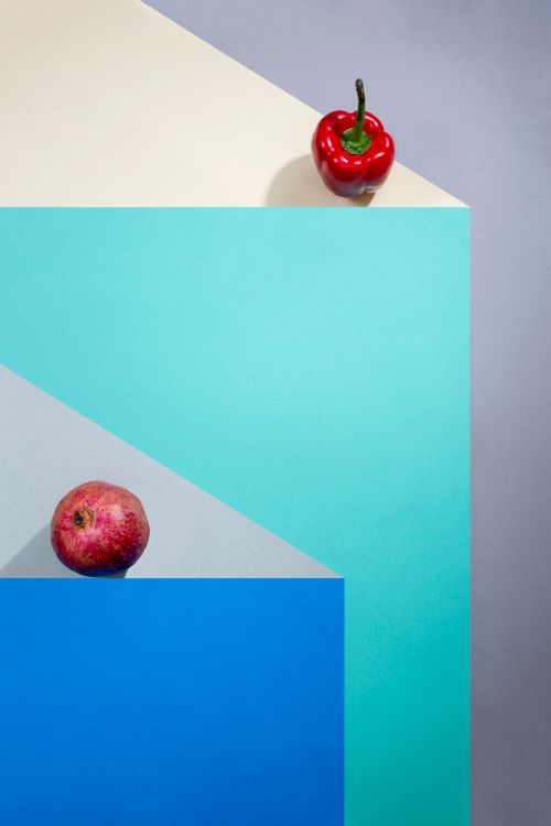 Free Top view of red apple and bell pepper on colorful geometric background, artistic still life. Stock Photo