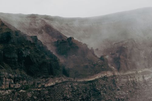 Free Atmospheric view of Mount Vesuvius crater engulfed in mist, capturing the rugged volcanic landscape. Stock Photo