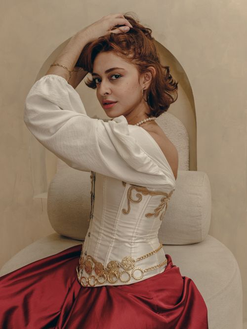 Free A woman in Victorian-inspired clothing poses elegantly indoors, exuding classic style. Stock Photo