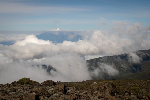 Free Scenic view of Kilimanjaro peak shrouded in clouds from the rocky highlands. Stock Photo
