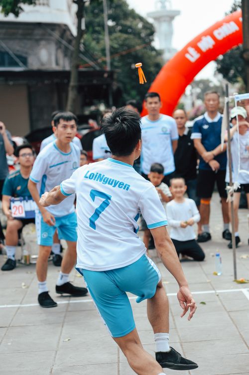 Free Group of men playing a traditional shuttlecock game outdoors, attracting spectators. Stock Photo