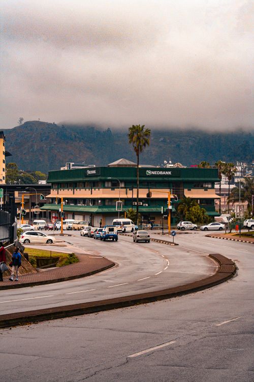 Free Busy intersection in Matsapha, Eswatini, with vehicles and urban buildings under cloudy skies. Stock Photo