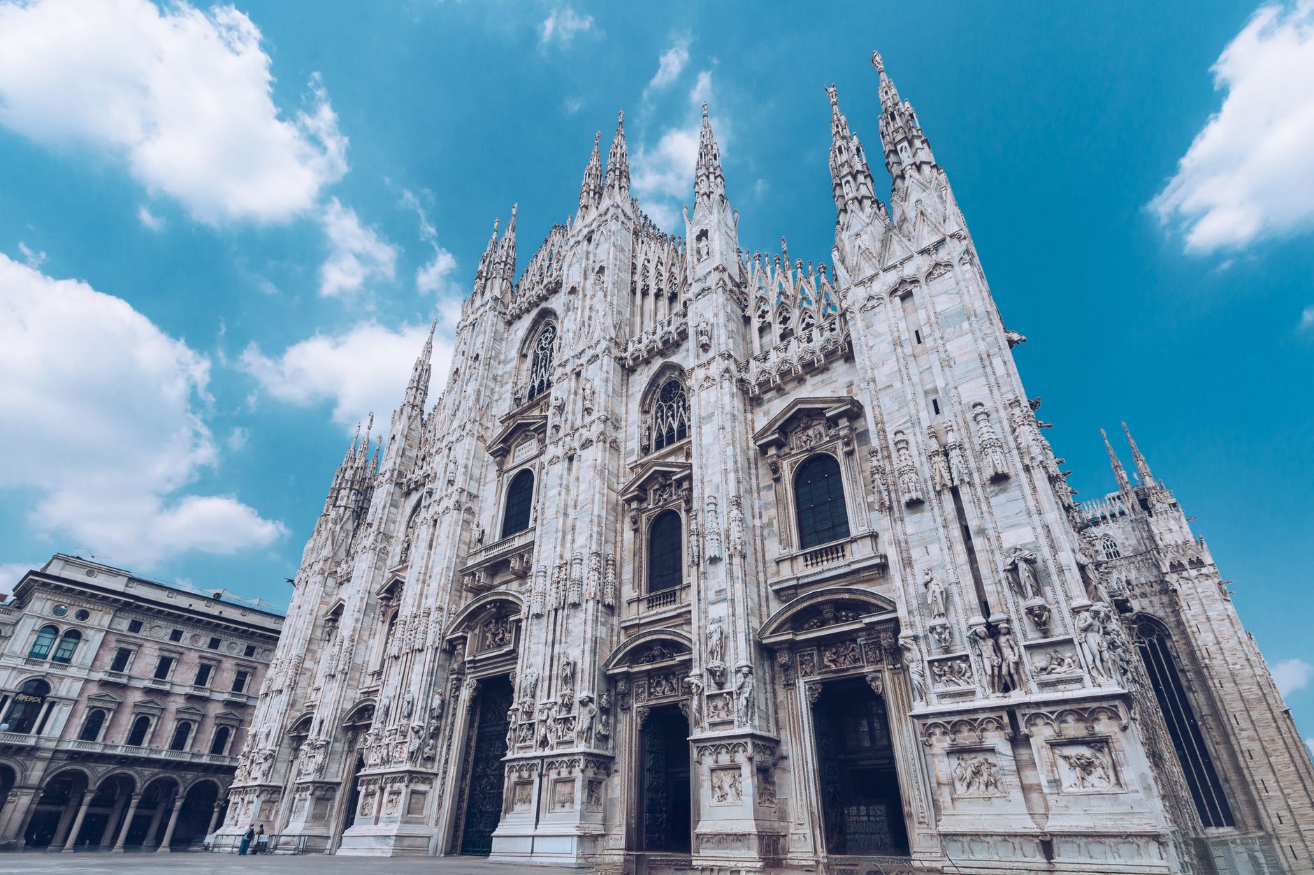 The stunning facade of Milan Cathedral under a bright blue sky, capturing Gothic grandeur.